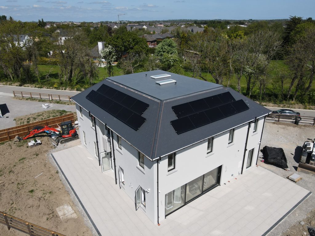 Solar panels installed on a newly built home. The home is detached with a paved patio surround