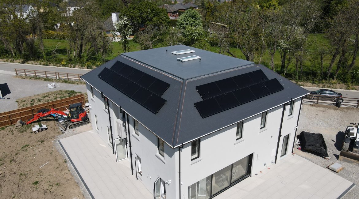 Solar panels installed on a newly built home. The home is detached with a paved patio surround