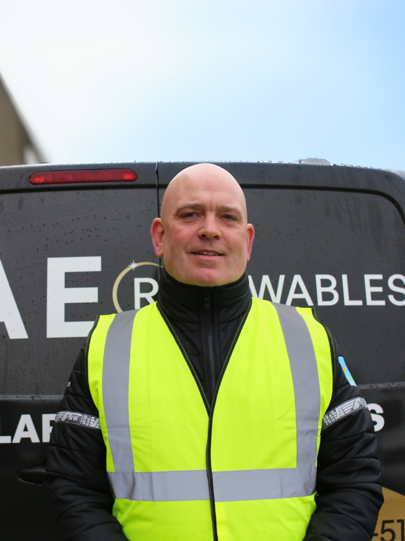 Stephen Brennan smiling in front of a DAE Renewables van